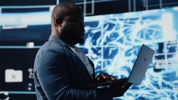 African american tech expert works with AI ethics and neural networks, virtual intelligence brain tools for machine learning systems. Algorithmic thinking development on dashboard. Camera B. video
