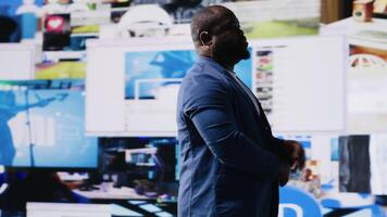 African American public speaker on stage surrounded by digital visuals, symbolizing a global conference where trends, mobile apps and AI powered content dominate modern communication. Camera B. video