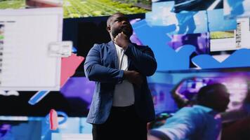 African American digital creator using dashboards with dynamic screens showcasing social media and networking, highlighting the importance of online engagement and global connection. Camera B. video