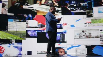 African American person engaged with mobile technology and multimedia feeds, showcasing the evolution of digital presence, communication and app interaction. Modern user interface. Camera A. video
