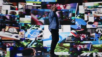 African american man connected to a global network through mobile devices, opening apps and streaming services platforms. Emphasizing communication and user interface evolution. Camera A. video