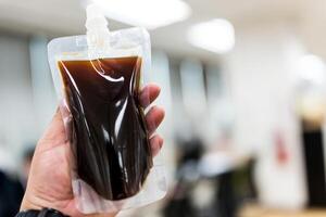 Cool coffee Americano in transparent bag for keep drink in home photo