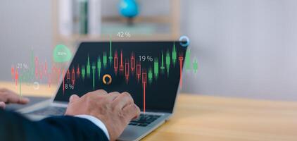 Investment, trading, business analytics, and global financial growth. Person analyzes financial data and stock market graphs on a laptop, with digital overlays showing percentages and charts. photo