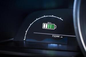 Electric vehicle dashboard showing a 100 percentage battery fully charge. EV, green energy, sustainable transport technology. photo