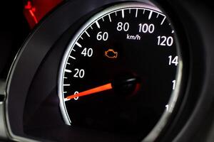 Check Engine Light Close Up, A car speedometer with an illuminated orange check engine light photo