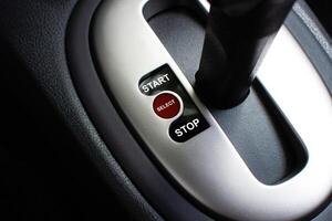 Selector Switch Lever, A close-up of a car gear shift console with START, SELECT, and STOP buttons. It may mean a symbol of start or stop. photo