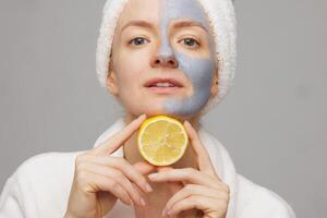 Confident Woman with Clay Facial Mask and Lemon, Spa Anti Aging Skin Care with Firming and Cleansing Effect photo