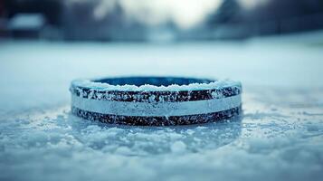 Close up of a hockey puck covered in frost on a frozen surface. photo