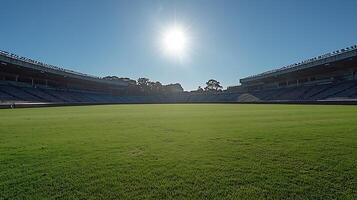 Sunlit stadium with vibrant green field and empty seating. photo