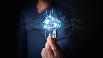 a person holding a lightbulb with a glowing, futuristic cloud hologram inside, surrounded by digital circuitry and connections, symbolizing innovation and cloud-based technology. photo