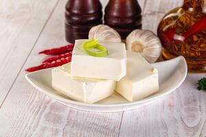 A white plate with some cheese and some peppers photo