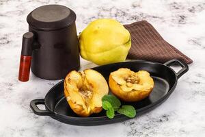 A black pan with two quinces and a tea pot photo