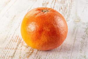 A single orange on a white table photo