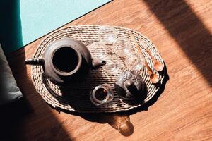 Morning tea ceremony in the meditation hall. Clay teapot, glass cups and wooden spoons on a tray, top view. Concept harmony, relaxation photo