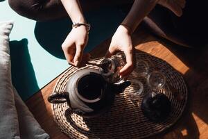 A person sitting on the floor with a tea pot photo