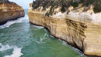 Aerial footage of rugged cliffs and turquoise waters at Loch Ard Gorge, showcasing natural beauty and dynamic ocean movement video