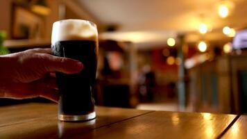 Hand reaches for a pint of stout video