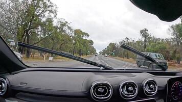 A car journey along Great Ocean Road, showcasing lush greenery and overcast skies, captured from inside a vehicle video