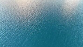Aerial footage captures serene blue ocean surface with gentle ripples under soft lighting video