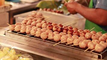 Vendor grilling sausages at floating market stall video