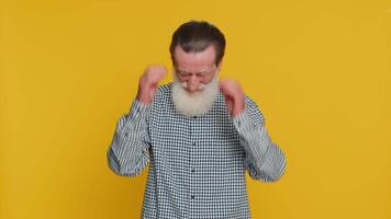 Sad senior old man feeling hopelessness loneliness, nervous breakdown, loses becoming surprised by lottery results, bad fortune, loss unlucky news. Mature grandfather isolated on yellow background video