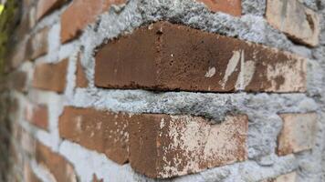 Close-up of weathered red brick wall with rough gray mortar joints photo