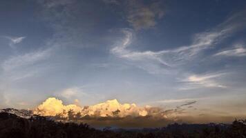 Golden Hour Over the Forest Clouds Bathed in Warm Light at Sunset photo