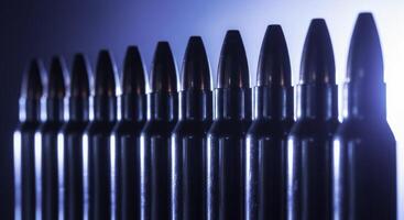 Perfectly aligned row of polished chrome rifle cartridges and bullets photo