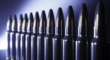 Perfectly aligned row of polished rifle cartridges with dark bullet tips photo