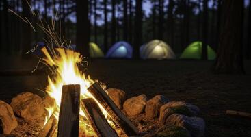Warm campfire flames and sparks at a night campsite with illuminated tents photo