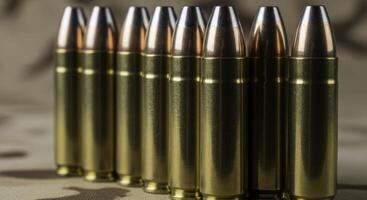 Close up of seven .45 caliber ammunition rounds with brass casings and silver projectiles standing upright photo