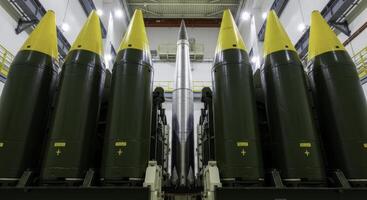 Six massive intercontinental ballistic missiles standing in a secure industrial facility photo