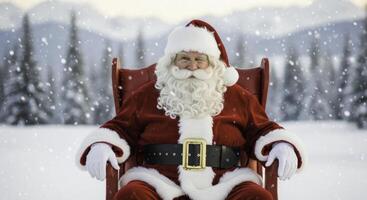 Smiling santa claus in red suit sitting in rocking chair in snowy winter landscape photo