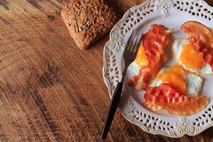 Breakfast , crispy bacon, fried eggs and bread. photo