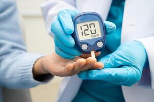 doctor using digital glucose meter for check sample blood diabetes. photo