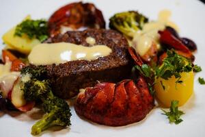 a white plate with fillet steak and Lobster photo