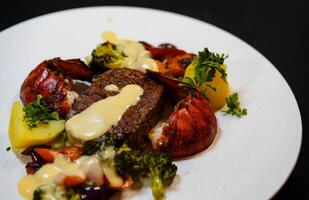 white plate with fillet steak and Lobster tail photo