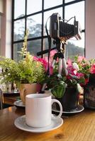 Old Camera on a Table with a Coffee Cup and Plants, Cozy Rustic Interior Still Life. Dalat, Vietnam. photo