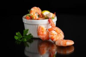 Juicy sea shrimps with lemon slices isolated on black background photo