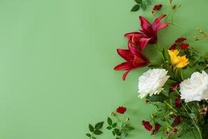 Detailed view of two large red lilies with red and white roses on a green background photo