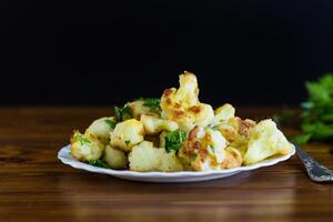Vegetable dish of fried cabbage with aromatic spices, black background photo