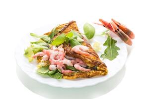 Appetizing breakfast omelet with shrimps and dill, on a white background photo