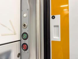 Close-up of train door panel with buttons and latch photo