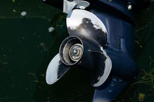 Close-up of boat propeller in water with algae photo