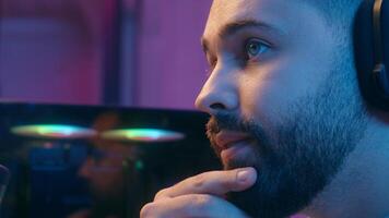 Concentrate serious close-up Caucasian man male guy gamer thinking pensive holding chin streamer talking microphone radio stream internet game web cyber sport addiction computer at home night photo