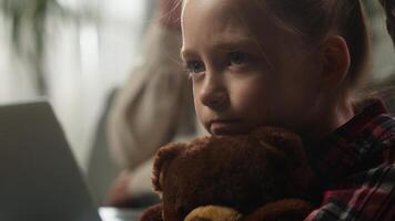 Caucasian family at home father working online with laptop ignoring sad frustrated offended upset lonely daughter hugging Teddy Bear toy child kid girl suffering dad ignorance attention deficit bored photo