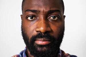 Close up image of African American man in his 30s showing boredom and displeasure, with a serious and anxious facial expression. photo