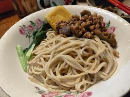 A bowl of noodles with meat and vegetables photo