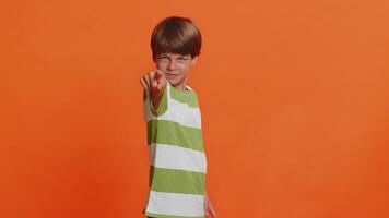 I choose you. Happy young preteen child boy kid pointing finger forward to camera, choosing lucky game winner, indicating to awesome you, promotion. Smiling little children on orange background video