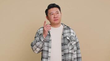 Need to think. Doubting pensive Asian middle-aged man pondering and imagining in mind, wondering difficult solution, feeling confused, not sure about choice. Mature Chinese guy on beige background. video